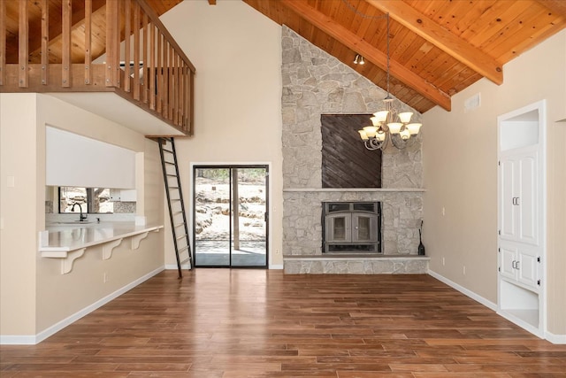 42617 John Muir Dr, Coarsegold, CA 93614 - unfurnished living room with high vaulted ceiling, wood finished floors, a chandelier, a wooden ceiling with exposed beams, and a fireplace