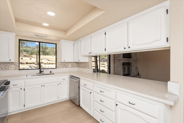 42617 John Muir Dr, Coarsegold, CA 93614 - kitchen featuring stainless steel dishwasher, a raised ceiling, white cabinetry, backsplash, and recessed lighting