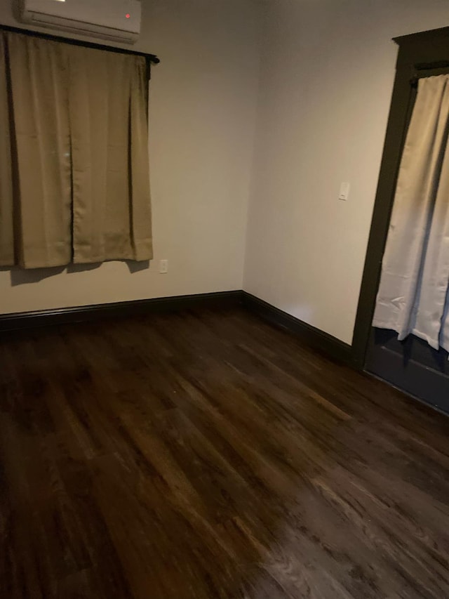 345 N Van Ness Ave, Fresno, CA 93701 - spare room featuring a wall mounted AC and dark wood finished floors