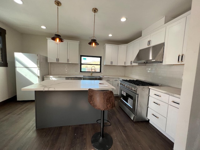 345 N Van Ness Ave, Fresno, CA 93701 - kitchen featuring under cabinet range hood, stainless steel range, freestanding refrigerator, dark wood-style floors, and white cabinetry