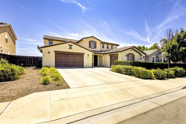 2286 N Janice Ave, Fresno, CA 93737 - mediterranean / spanish-style home featuring a garage, stucco siding, a tile roof, and concrete driveway