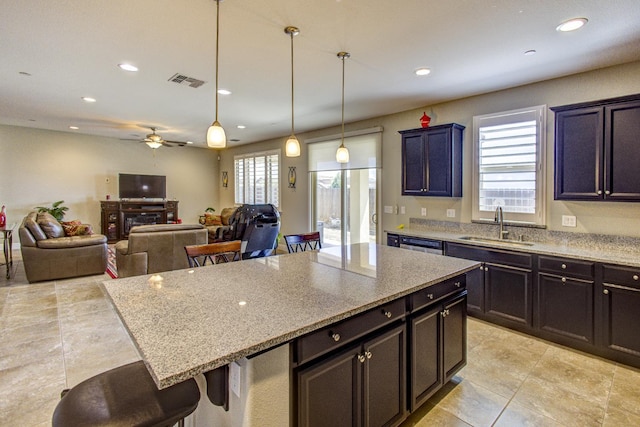 2286 N Janice Ave, Fresno, CA 93737 - kitchen with a kitchen bar, ceiling fan, a center island, recessed lighting, and light stone counters