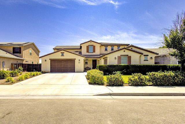 2286 N Janice Ave, Fresno, CA 93737 - mediterranean / spanish-style home featuring stucco siding, an attached garage, driveway, and a tiled roof