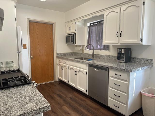 5509 E Crescent Ave, Fresno, CA 93727 - kitchen featuring appliances with stainless steel finishes, dark wood-type flooring, white cabinetry, and light stone counters