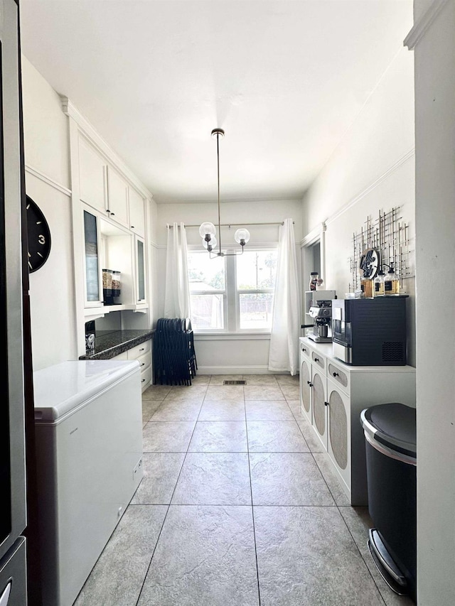 3728 E Huntington Blvd, Fresno, CA 93702 - kitchen featuring white cabinets, glass insert cabinets, a chandelier, fridge, and light tile patterned flooring