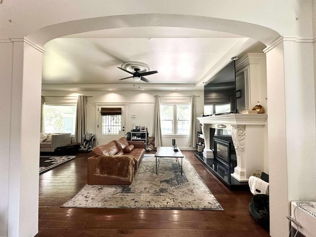 3728 E Huntington Blvd, Fresno, CA 93702 - living area featuring arched walkways, dark wood finished floors, a ceiling fan, and a glass covered fireplace