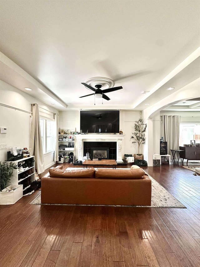 3728 E Huntington Blvd, Fresno, CA 93702 - living room with arched walkways, a ceiling fan, hardwood / wood-style floors, a fireplace, and a raised ceiling
