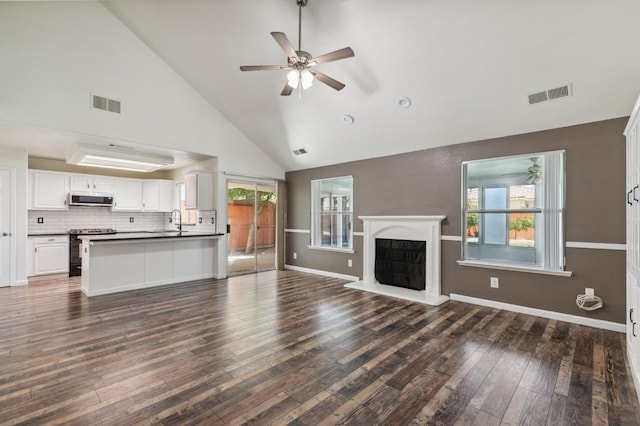 2111 Birch Ave, Clovis, CA 93611 - unfurnished living room featuring high vaulted ceiling, a ceiling fan, dark wood-type flooring, and a fireplace with raised hearth