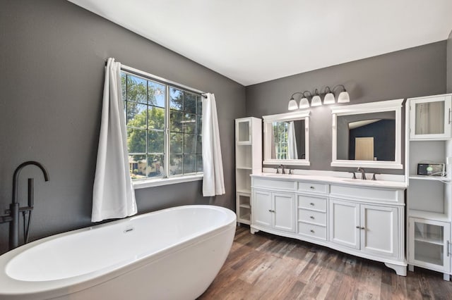 2111 Birch Ave, Clovis, CA 93611 - bathroom featuring double vanity, a freestanding tub, and wood finished floors
