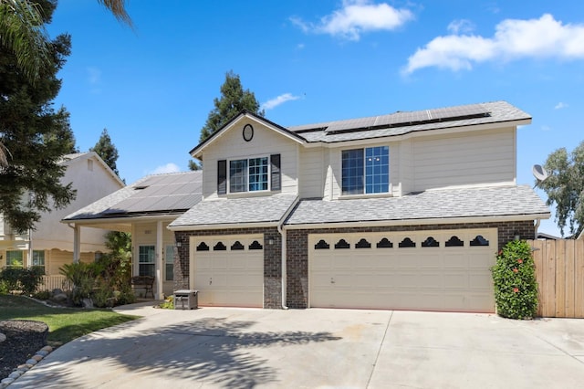 2111 Birch Ave, Clovis, CA 93611 - view of front of home with an attached garage, roof mounted solar panels, concrete driveway, and brick siding