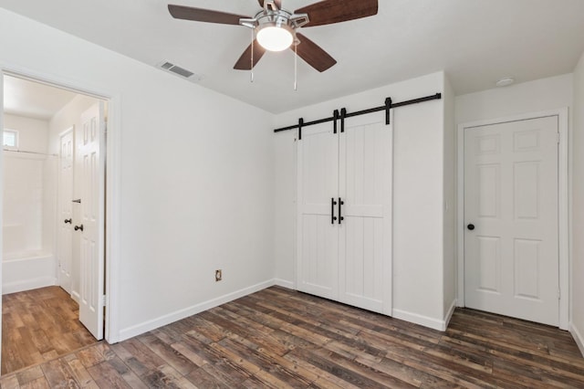 2111 Birch Ave, Clovis, CA 93611 - unfurnished bedroom with a barn door, dark wood-style floors, ensuite bathroom, and a closet