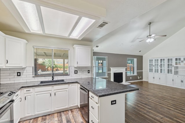2111 Birch Ave, Clovis, CA 93611 - kitchen with appliances with stainless steel finishes, open floor plan, a peninsula, wood finished floors, and backsplash