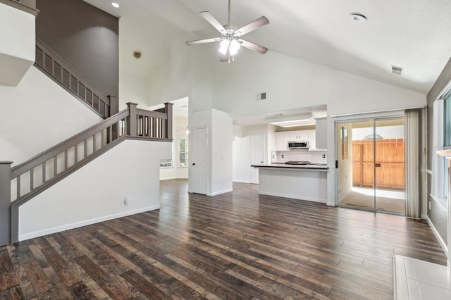 2111 Birch Ave, Clovis, CA 93611 - unfurnished living room with dark wood-style floors, high vaulted ceiling, ceiling fan, and stairs