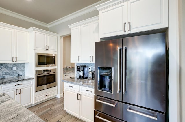 3211 Salem Ave, Clovis, CA 93619 - kitchen with stainless steel appliances, white cabinetry, decorative backsplash, light wood finished floors, and ornamental molding