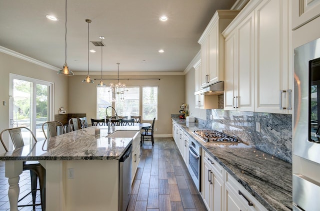 3211 Salem Ave, Clovis, CA 93619 - kitchen with a breakfast bar area, appliances with stainless steel finishes, a large island with sink, white cabinets, and crown molding