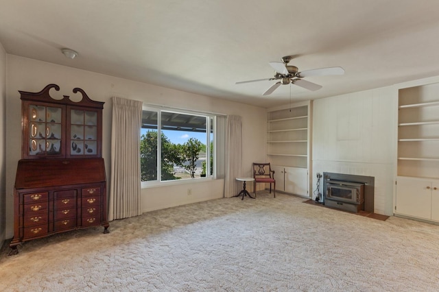 1432 E Holland Ave, Fresno, CA 93704 - sitting room with a wood stove, carpet, ceiling fan, and built in shelves