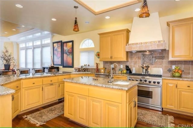 325 Juanita Ave, Oceano, CA 93445 - kitchen featuring stainless steel range, custom exhaust hood, a center island with sink, light stone countertops, and decorative backsplash