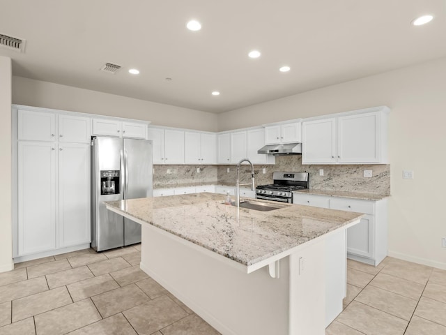 3433 Descanso Ave, Clovis, CA 93619 - kitchen featuring appliances with stainless steel finishes, under cabinet range hood, white cabinets, a kitchen island with sink, and recessed lighting