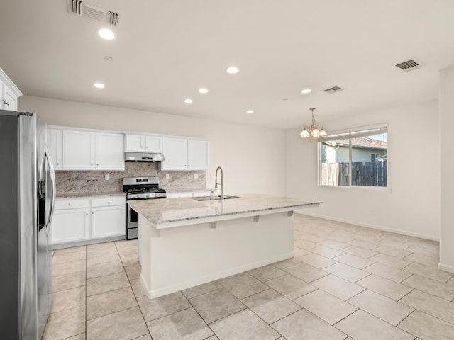 3433 Descanso Ave, Clovis, CA 93619 - kitchen with stainless steel appliances, light tile patterned flooring, under cabinet range hood, decorative backsplash, and a chandelier