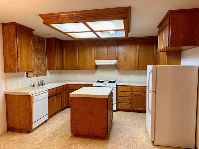 13308 Hood Ave, Hanford, CA 93230 - kitchen featuring white appliances, under cabinet range hood, tile countertops, light flooring, and a kitchen island