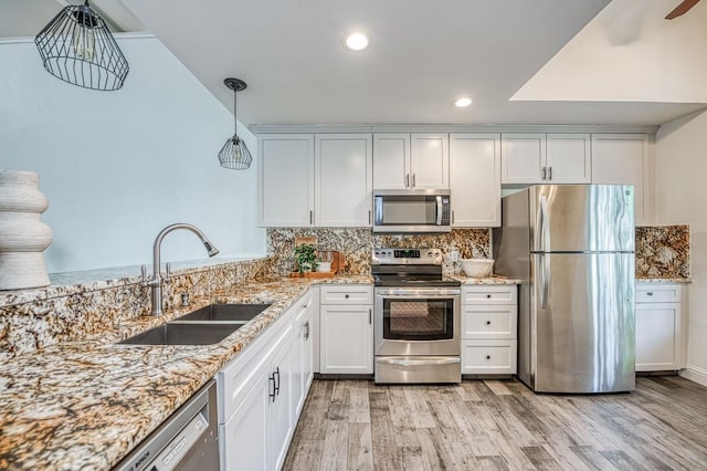 9224 N Stoneridge Ln, Fresno, CA 93720 - kitchen with appliances with stainless steel finishes, light wood-style floors, light stone counters, recessed lighting, and white cabinets