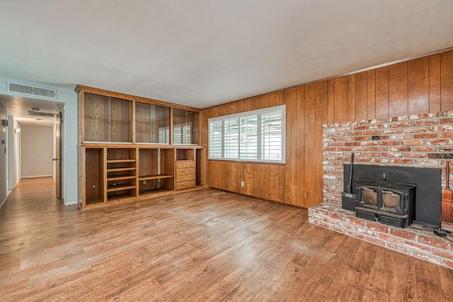 5578 E Perrin Rd, Clovis, CA 93619 - unfurnished living room featuring wood finished floors, a wood stove, and wooden walls
