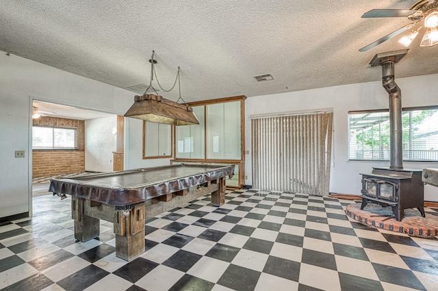 5578 E Perrin Rd, Clovis, CA 93619 - rec room featuring tile patterned floors, a ceiling fan, plenty of natural light, a wood stove, and brick wall