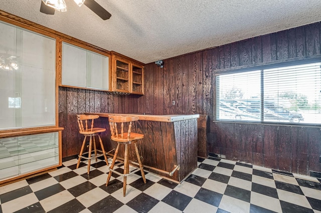 5578 E Perrin Rd, Clovis, CA 93619 - indoor dry bar featuring tile patterned floors, wooden walls, a textured ceiling, and a ceiling fan