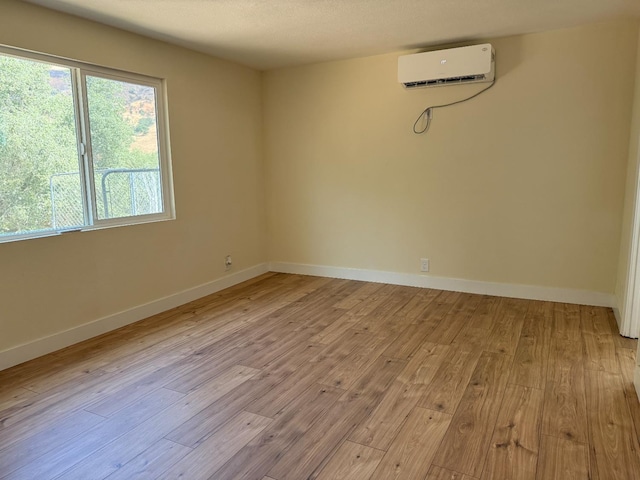 1248 Crane Ln, Yokuts Valley, CA 93675 - spare room with an AC wall unit and light wood-style floors