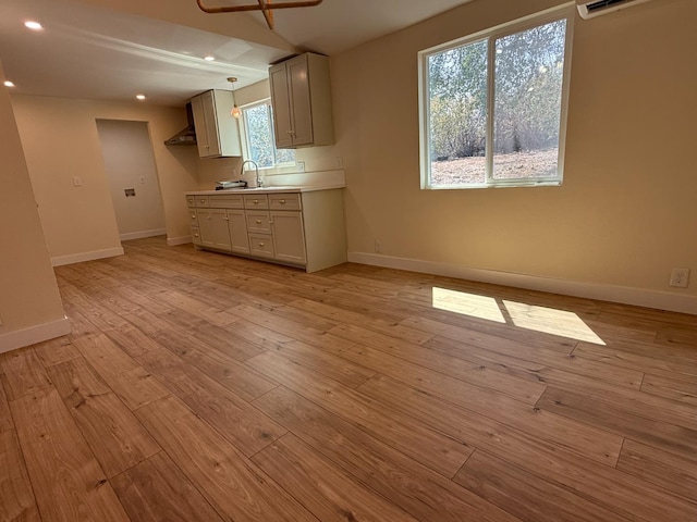 1248 Crane Ln, Yokuts Valley, CA 93675 - kitchen featuring light wood-type flooring, recessed lighting, light countertops, a wall mounted AC, and pendant lighting