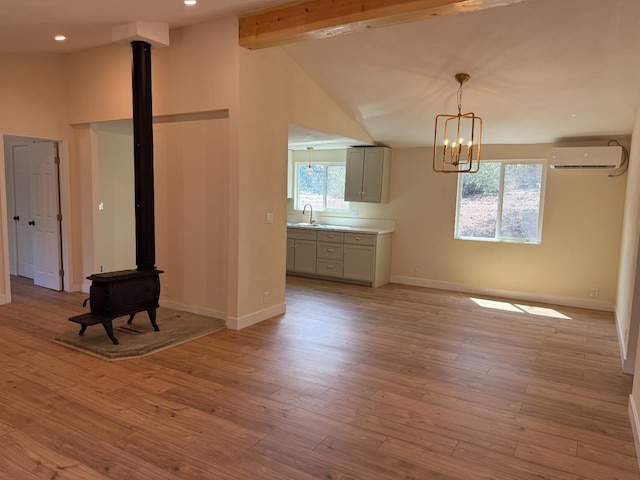 1248 Crane Ln, Yokuts Valley, CA 93675 - unfurnished living room featuring a wall mounted air conditioner, a wood stove, light wood-type flooring, a chandelier, and recessed lighting