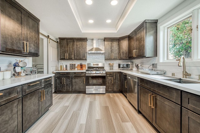 254 W Sierra Ave, Clovis, CA 93612 - kitchen with stainless steel appliances, wall chimney range hood, a raised ceiling, dark brown cabinets, and ornamental molding