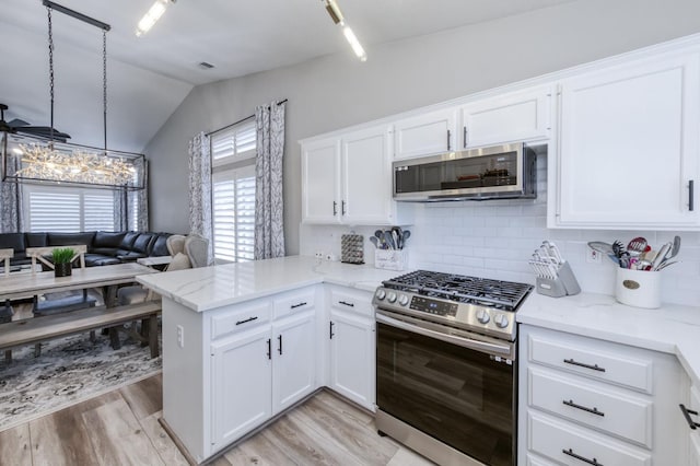 1760 E Ticonderoga Dr, Fresno, CA 93720 - kitchen featuring stainless steel appliances, vaulted ceiling, light wood finished floors, a peninsula, and decorative backsplash