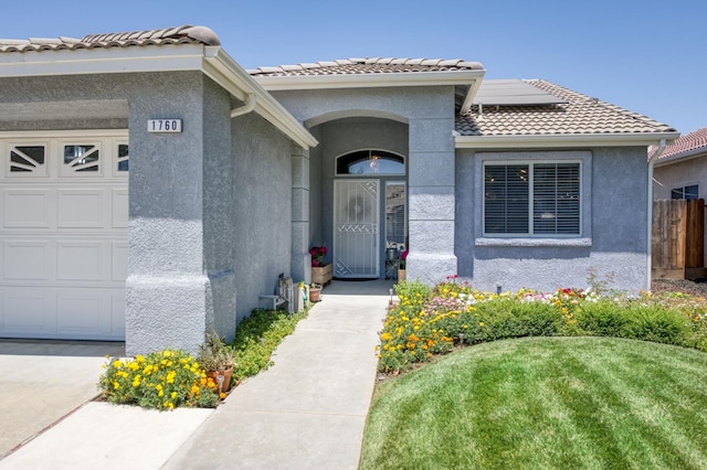 1760 E Ticonderoga Dr, Fresno, CA 93720 - entrance to property with an attached garage, stucco siding, roof mounted solar panels, and a tiled roof
