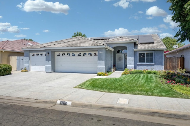 1760 E Ticonderoga Dr, Fresno, CA 93720 - mediterranean / spanish-style home featuring stucco siding, a tile roof, an attached garage, concrete driveway, and solar panels