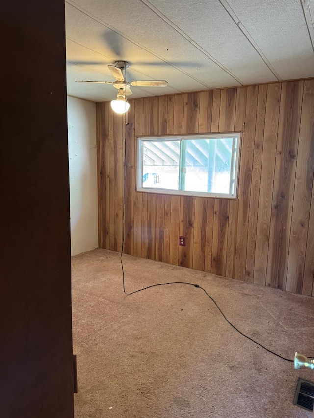 50481 Sundew Rd, Yokuts Valley, CA 93675 - spare room with wood walls, carpet floors, and ceiling fan