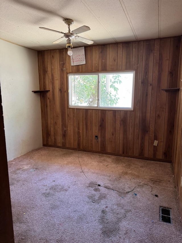 50481 Sundew Rd, Yokuts Valley, CA 93675 - spare room with wooden walls, a ceiling fan, carpet flooring, and a textured ceiling
