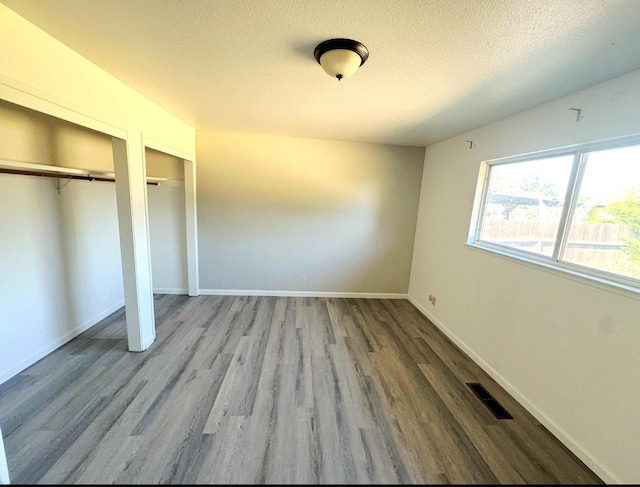 3122 Belmira Rd, Atwater, CA 95301 - unfurnished bedroom featuring a textured ceiling, two closets, and wood finished floors