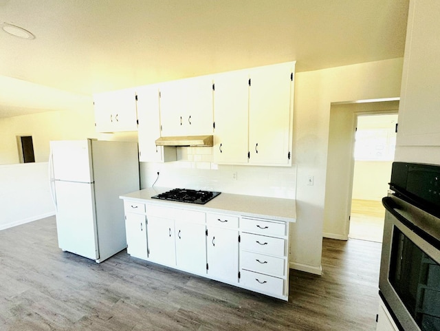 3122 Belmira Rd, Atwater, CA 95301 - kitchen featuring freestanding refrigerator, wood finished floors, stainless steel oven, black gas stovetop, and decorative backsplash