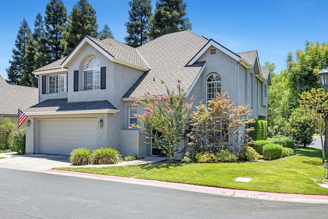 3075 W Silverhill Ln, Fresno, CA 93711 - traditional-style house with stucco siding, a front lawn, an attached garage, driveway, and roof with shingles
