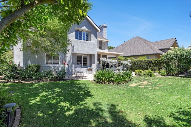 3075 W Silverhill Ln, Fresno, CA 93711 - back of property featuring a patio, stucco siding, a chimney, and a lawn