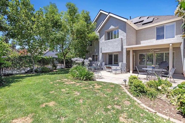 3075 W Silverhill Ln, Fresno, CA 93711 - back of property with solar panels, stucco siding, ceiling fan, a patio area, and a fenced backyard