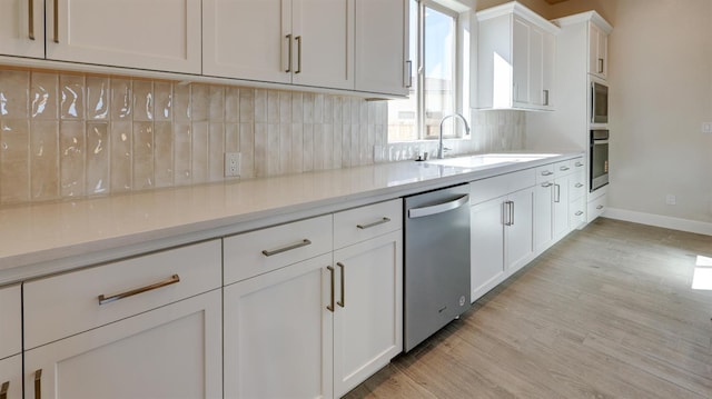 951 Talus Way S, Madera, CA 93636 - kitchen with stainless steel appliances, light wood-type flooring, backsplash, white cabinets, and light stone counters