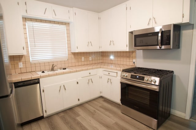 2449 S Page Ave, Fresno, CA 93725 - kitchen featuring stainless steel appliances, light wood-style flooring, and white cabinets