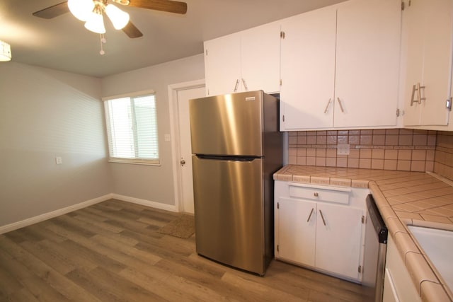 2449 S Page Ave, Fresno, CA 93725 - kitchen with appliances with stainless steel finishes, tile counters, white cabinetry, and a ceiling fan