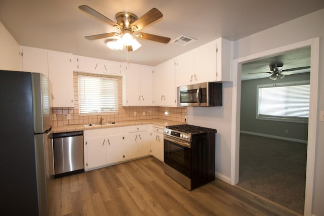 2449 S Page Ave, Fresno, CA 93725 - kitchen with appliances with stainless steel finishes, ceiling fan, tile countertops, and backsplash