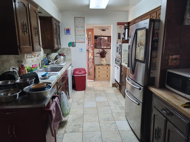 1621 W Holland Ave, Fresno, CA 93705 - kitchen with appliances with stainless steel finishes, decorative backsplash, dark brown cabinetry, and light countertops