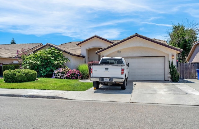 3742 Via Capitola, Madera, CA 93637 - mediterranean / spanish house with a garage, driveway, stucco siding, a tiled roof, and a front yard