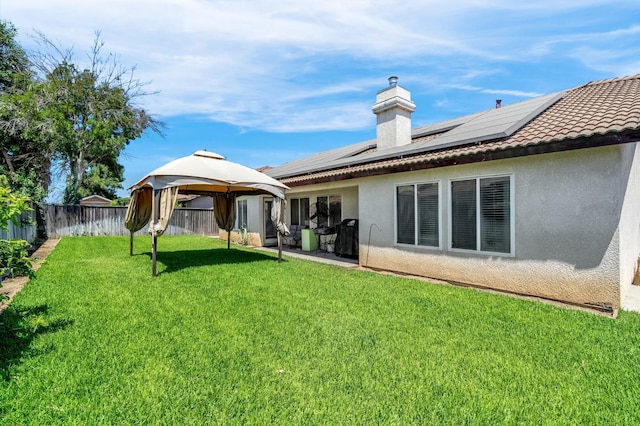 3742 Via Capitola, Madera, CA 93637 - rear view of property featuring a gazebo, solar panels, a fenced backyard, stucco siding, and a tiled roof