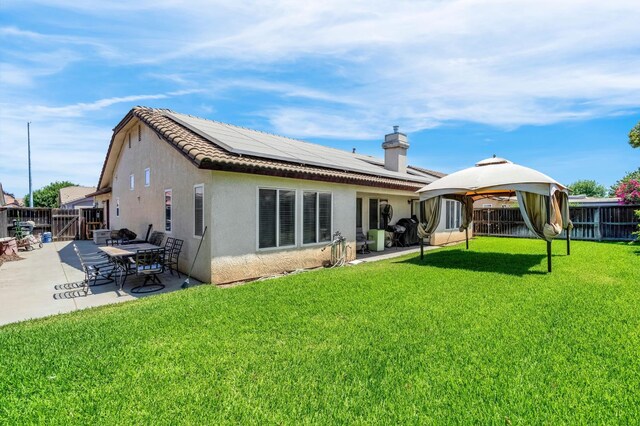 3742 Via Capitola, Madera, CA 93637 - back of house featuring a gazebo, roof mounted solar panels, a fenced backyard, and a patio area